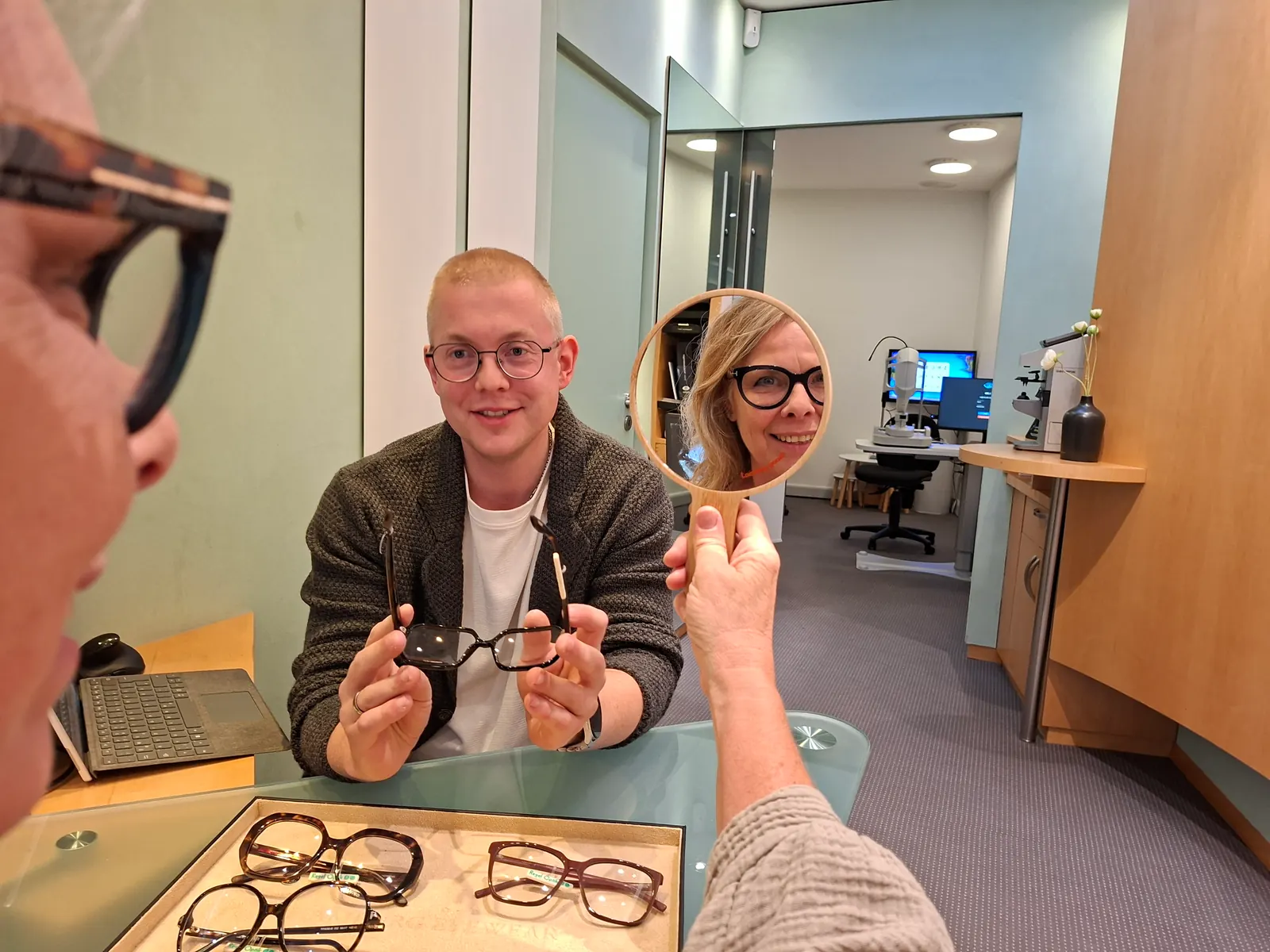 Persönliche Sehberatung bei Regel Optik – Kundin betrachtet ihre neue Brille im Handspiegel